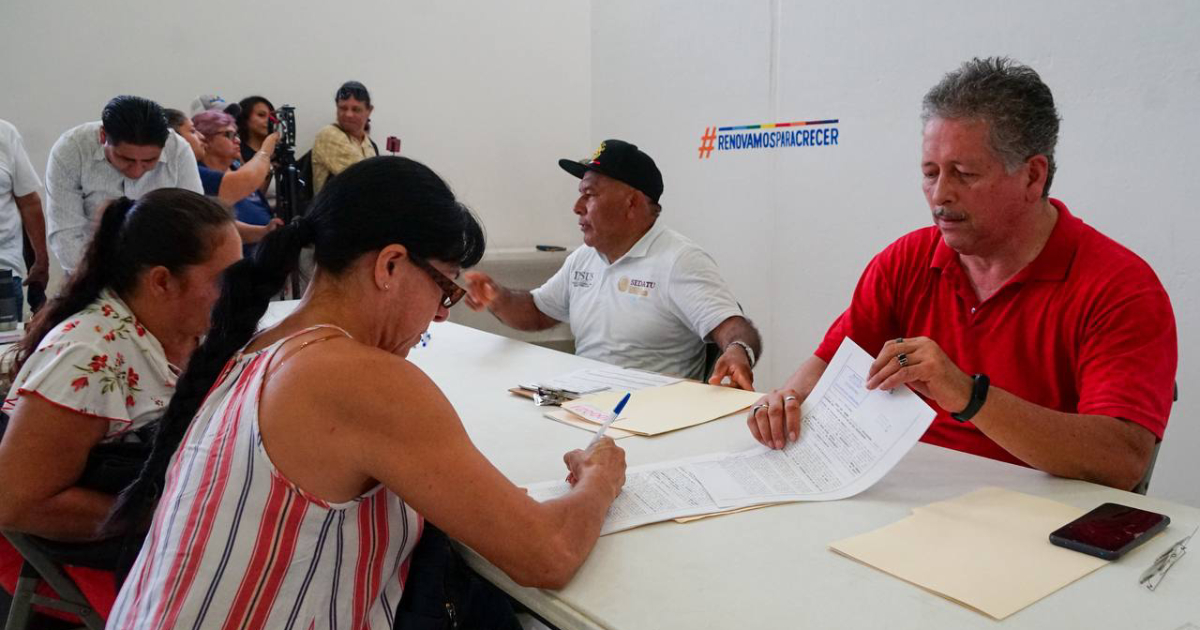 Foto de familias firmando escrituras de Cristo Rey